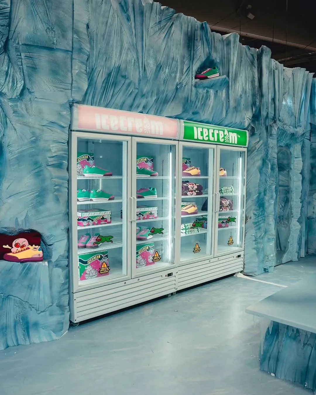 Inside the ICECREAM store: two glass freezers of sneakers set into a wall of carved blue ice